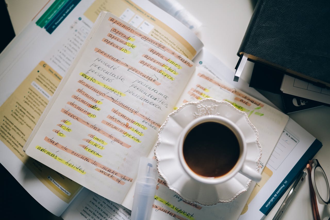 Home A cup of coffee on handwritten Spanish notes for language learning inspiration.
